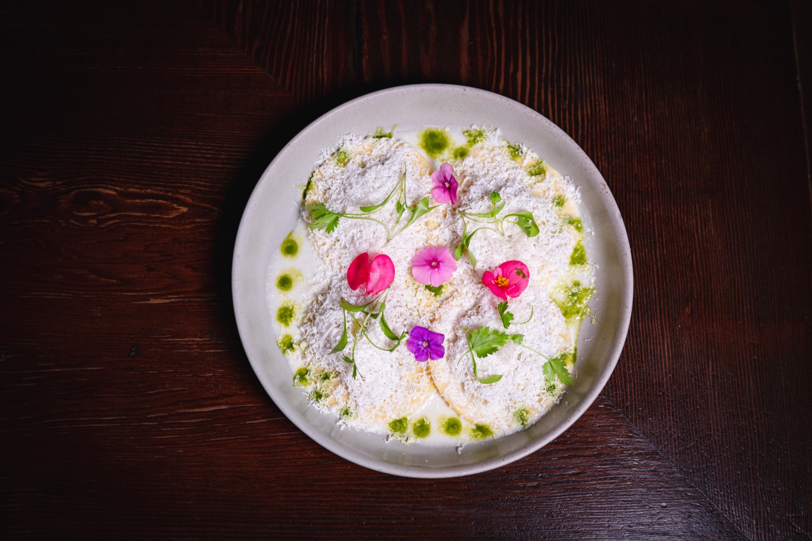 A seasonal share plate finished with edible flowers from Blue Moon Acres and basil oil at WEST10WEST