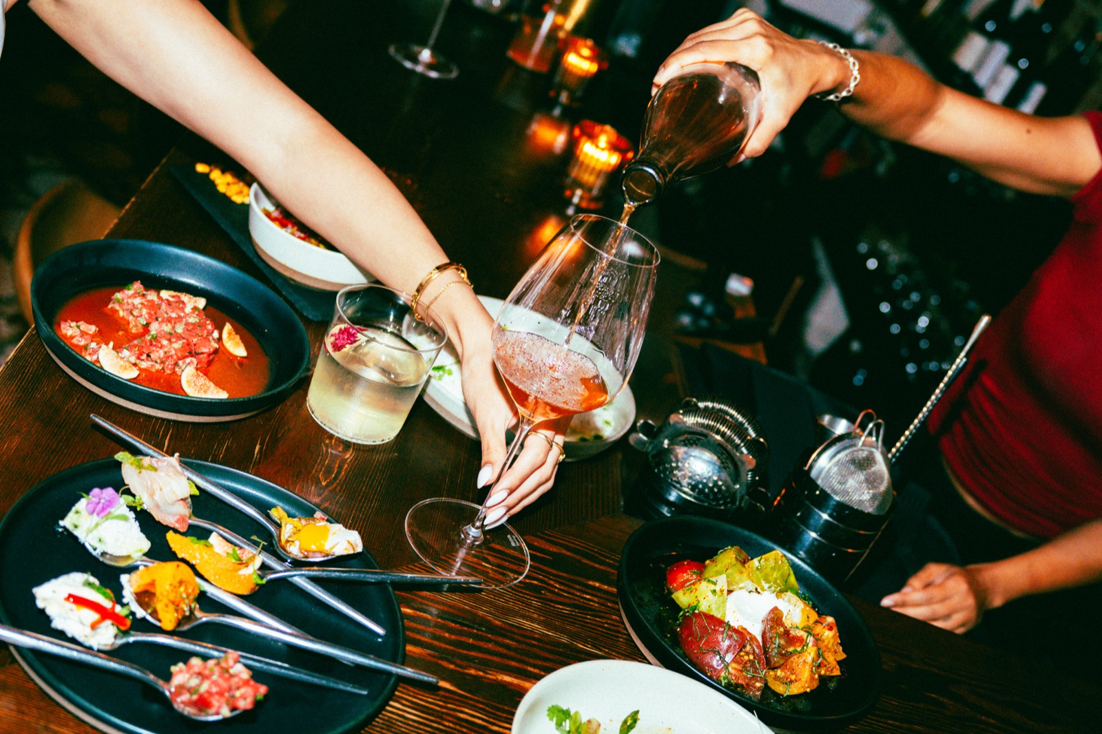 Wine poured tableside over a spread of share plates at WEST10WEST, an intimate West Village restaurant