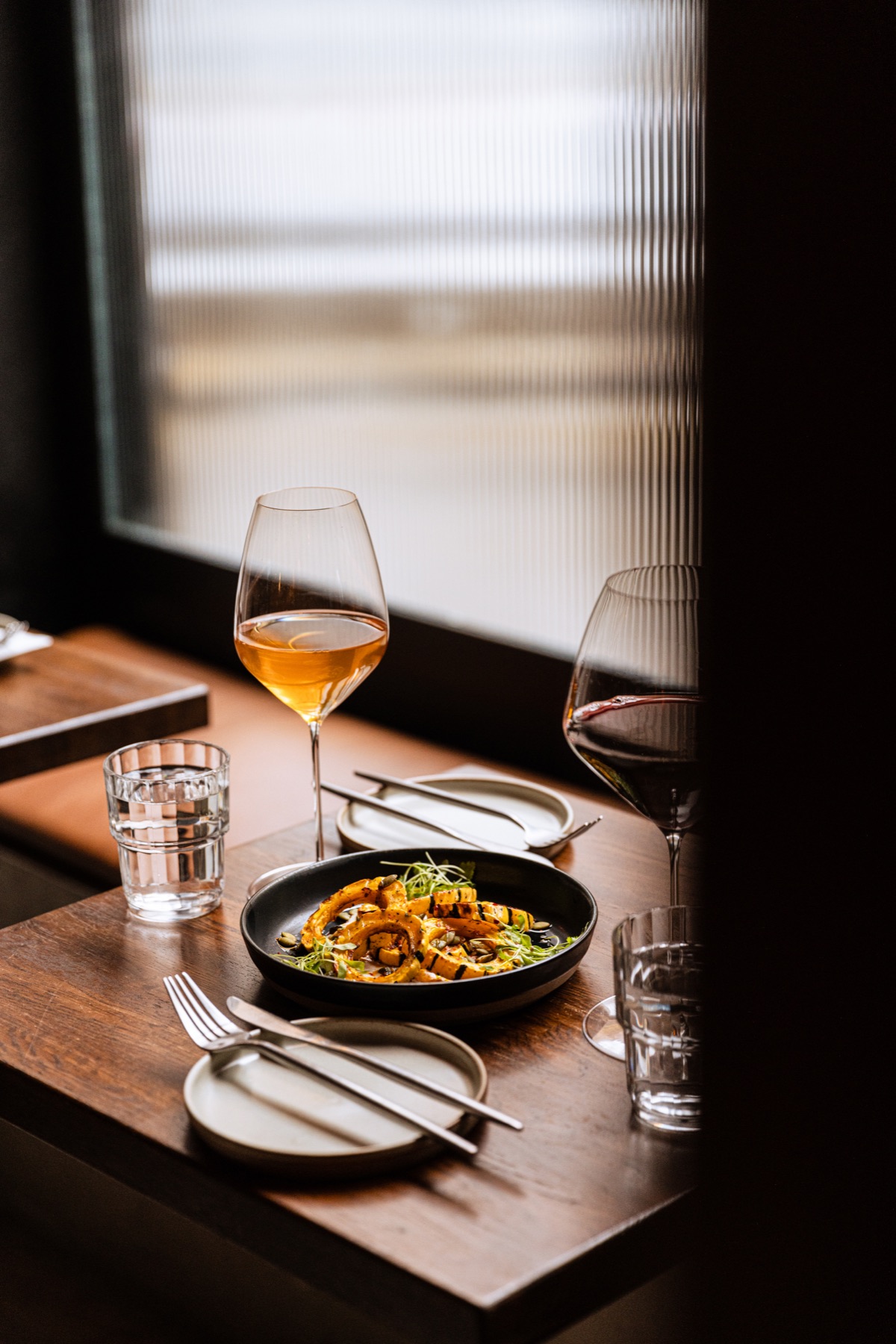 Orange wine, red wine, and delicata squash on the window counter